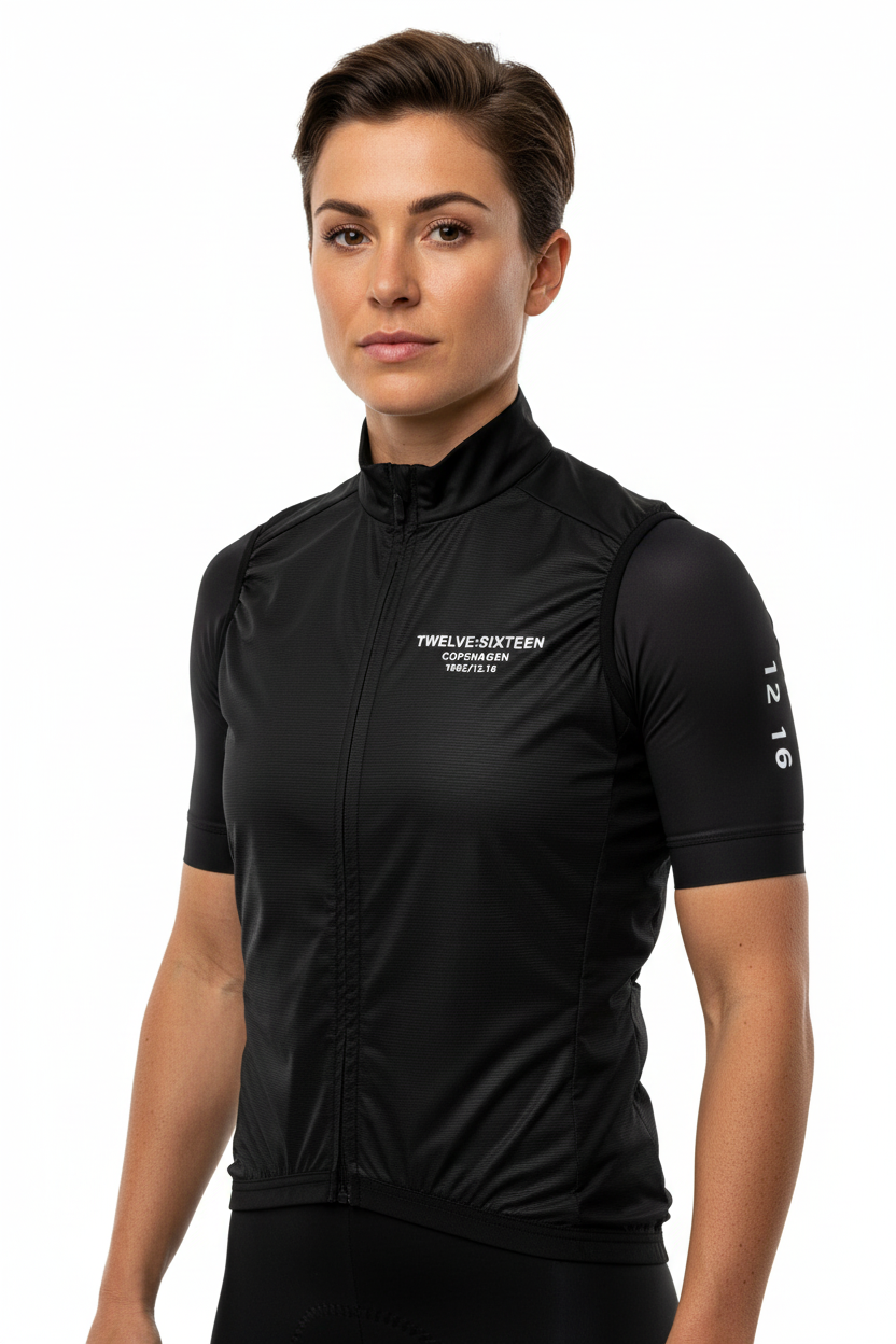 Woman wearing a black cycling gilet with '1216' branding 